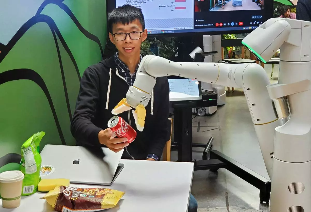 An Everyday Robot is seen grabbing Coca-Cola can. 