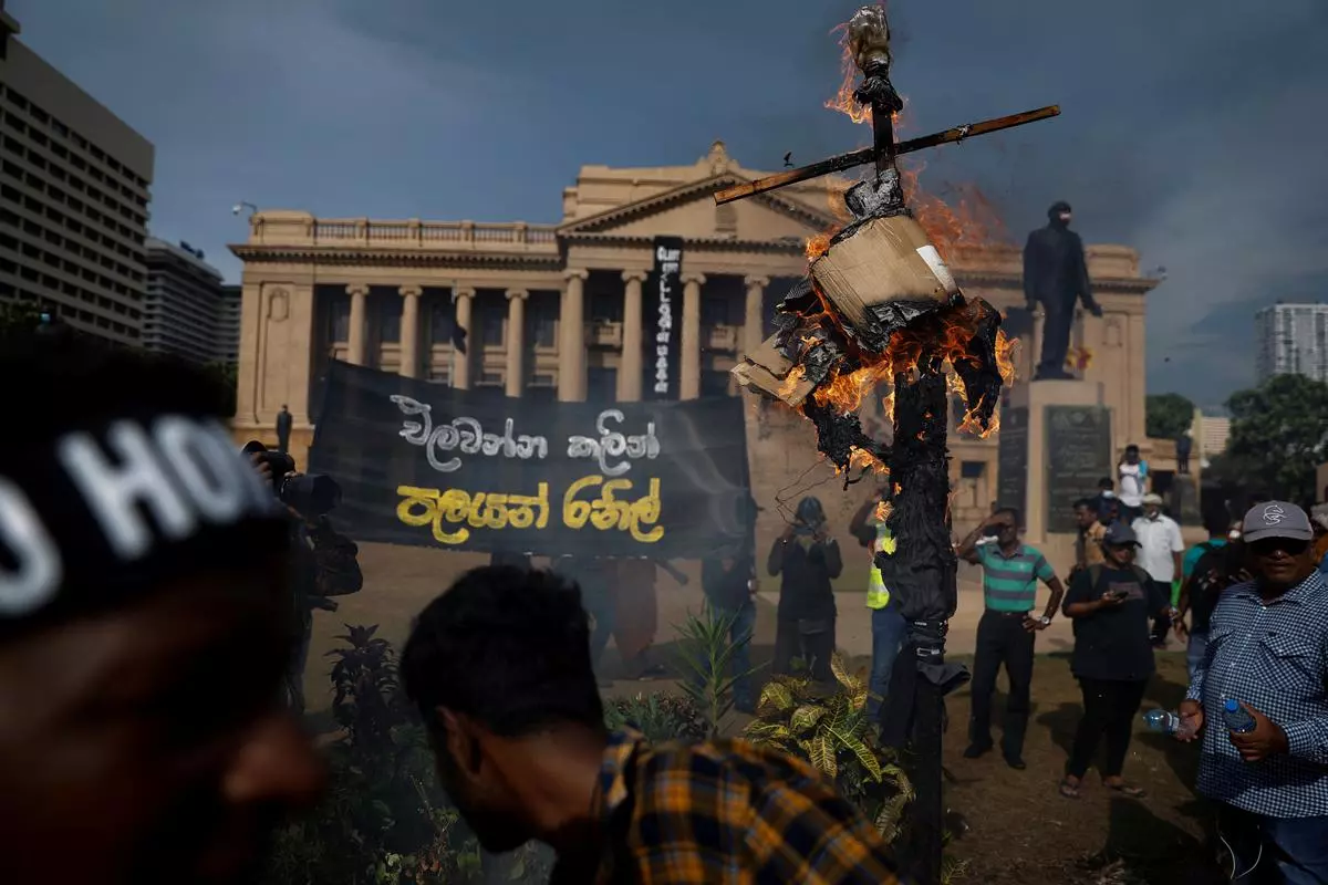 Protestors burn an effigy of Acting President Ranil Wickremesinghe during a protest outside the Presidential Secretariat, in Colombo on Tuesday