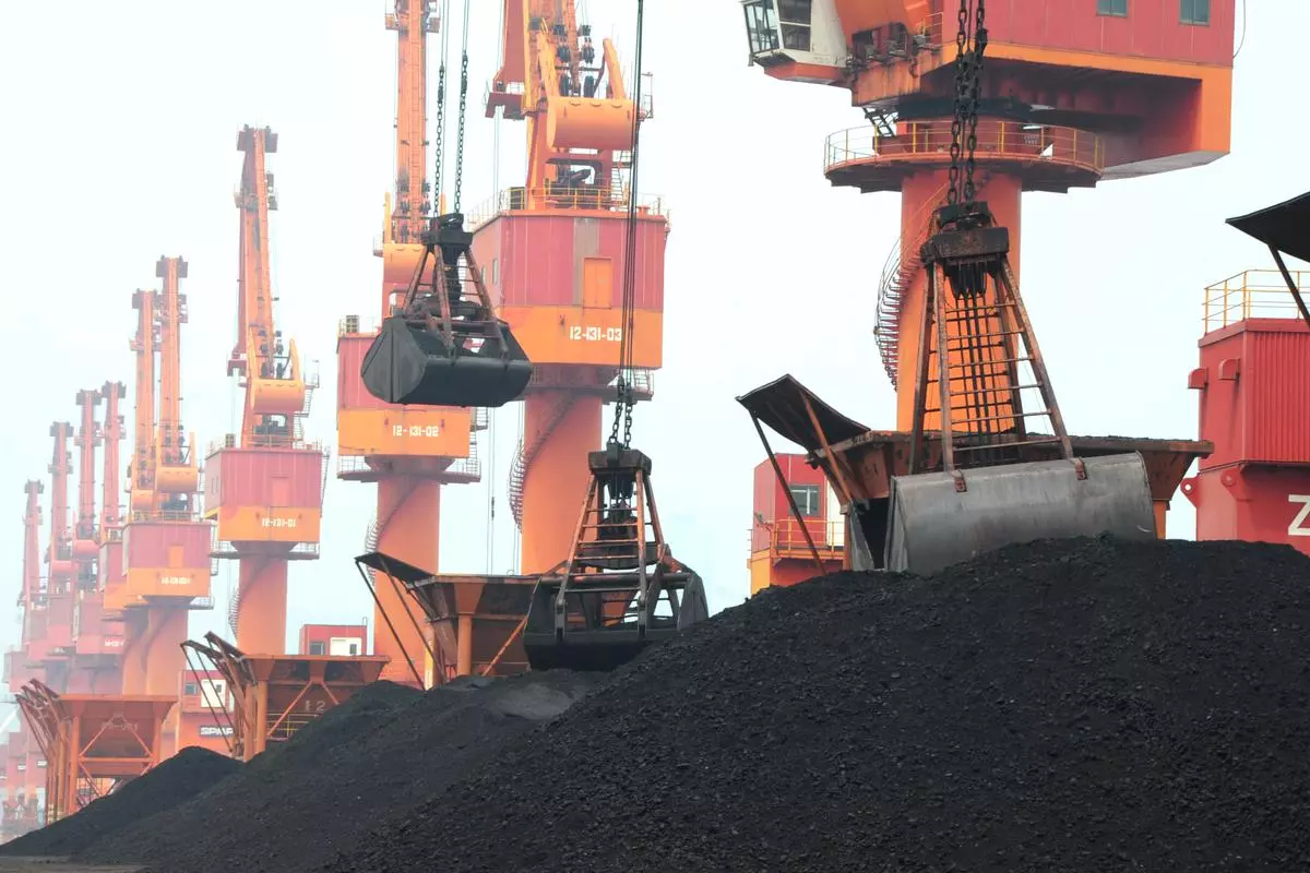 Imported coal is seen lifted by cranes from a coal cargo ship at a port in Lianyungang, Jiangsu province, China 