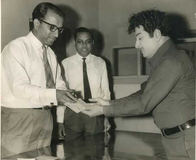 A General Manager of Glaxo Laboratory, is seen handing over a cheque for Rs. 2 lakhs for investment in small savings to M.G. Ramachandran, Vice-Chairman, State Small Savings Advisory Board on December 9, 1970, at Satya Studios, Madras.
PHOTO: THE HINDU ARCHIVES A General Manager of Glaxo Laboratory, is seen handing over a cheque for Rs. 2 lakhs for investment in small savings to M.G. Ramachandran, Vice-Chairman, State Small Savings Advisory Board on December 9, 1970, at Satya Studios, Madras.
PHOTO: THE HINDU ARCHIVES