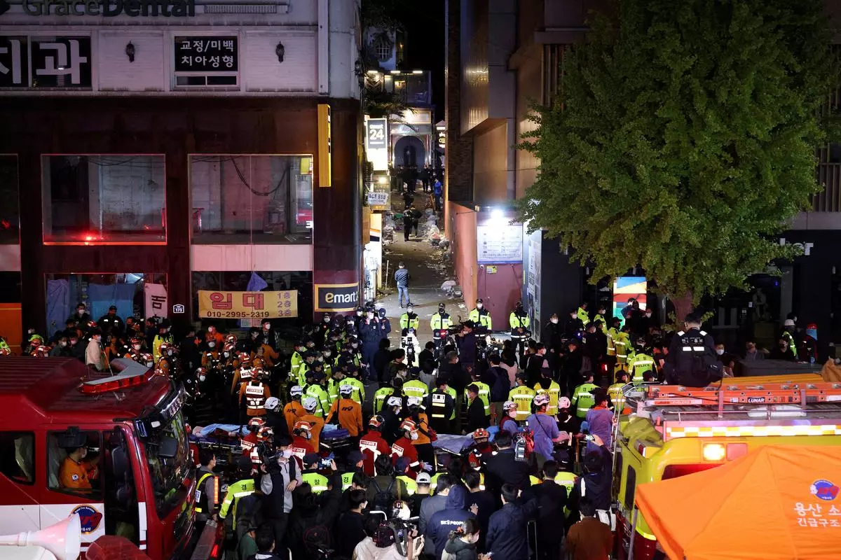 Rescue teams and firefighters work at the scene where dozens of people were injured in a stampede during a Halloween festival in Seoul, South Korea, on Sunday. 