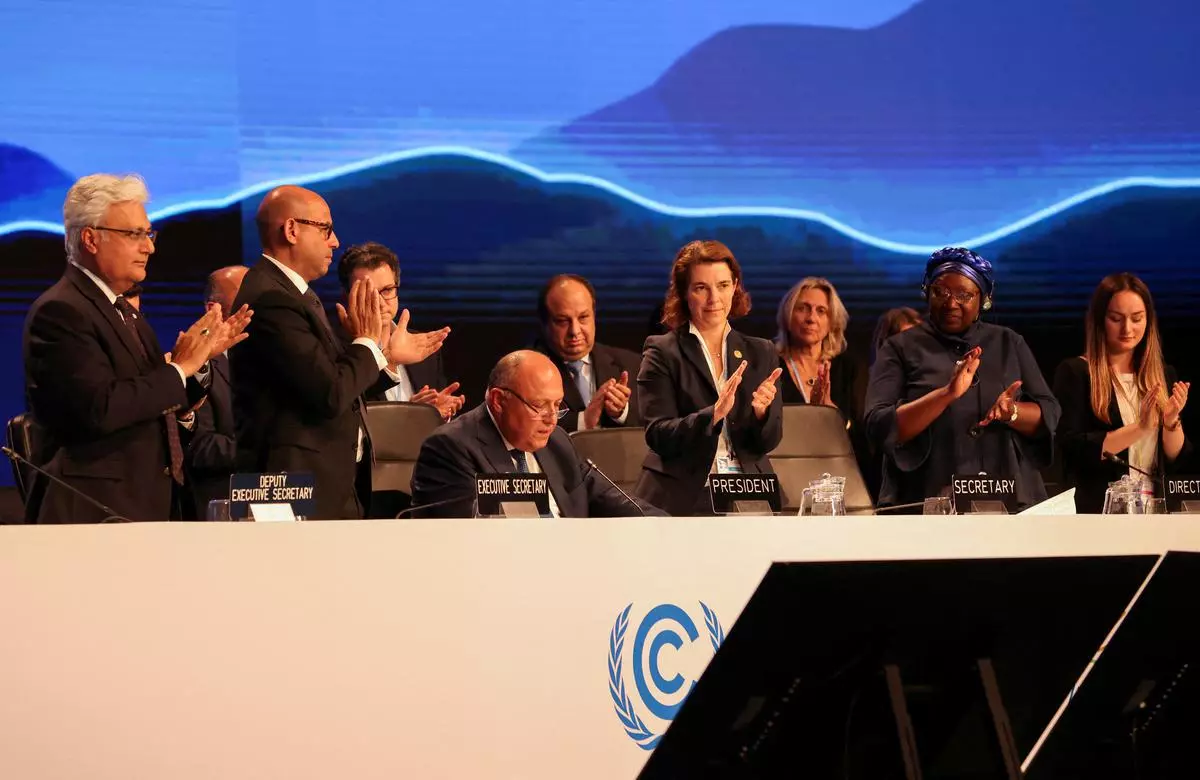 Delegates applaud as COP27 President Sameh Shoukry delivers a statement during the closing plenary at the COP27 climate summit in Red Sea resort of Sharm el-Sheikh, Egypt, on Sunday