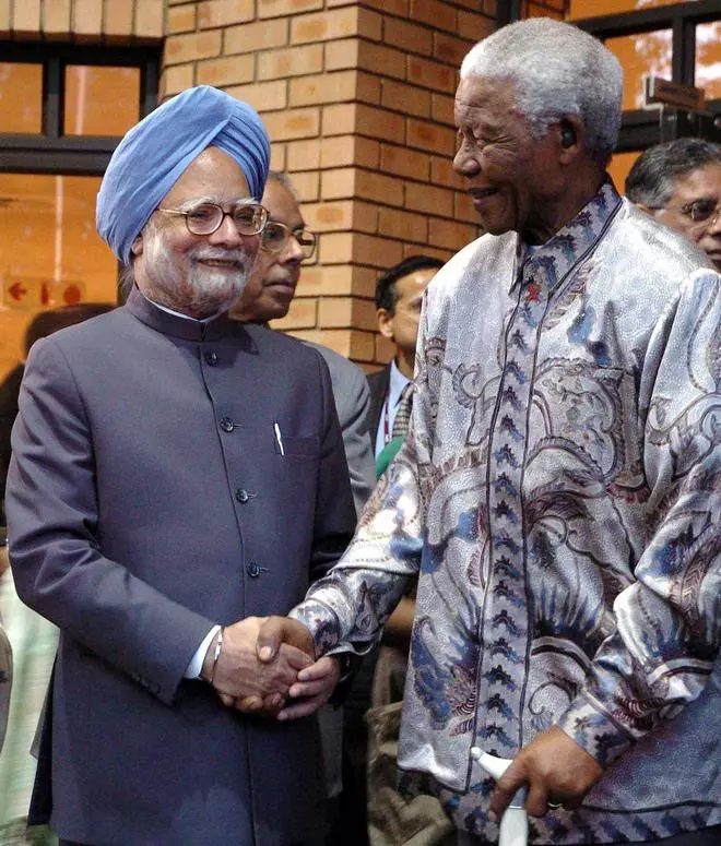 In this file photo from October 2, 2006, former South African President Nelson Mandela is seen with Prime Minister Manmohan Singh at a function in Johannesburg.