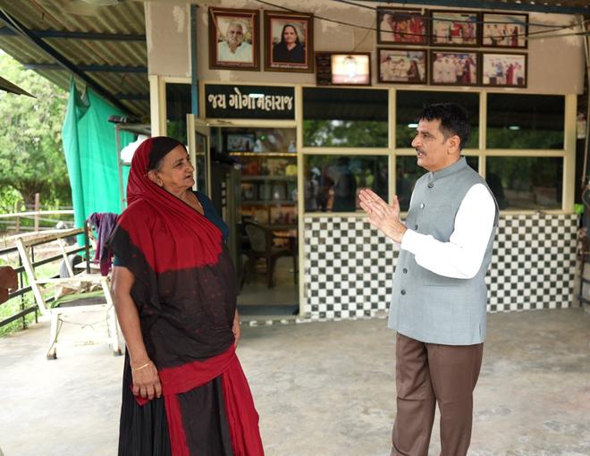 Banas Dairy Chairman Shankar Chaudhary interacts with Navalben Chaudhary at her farm in Banaskantha district of Gujarat 