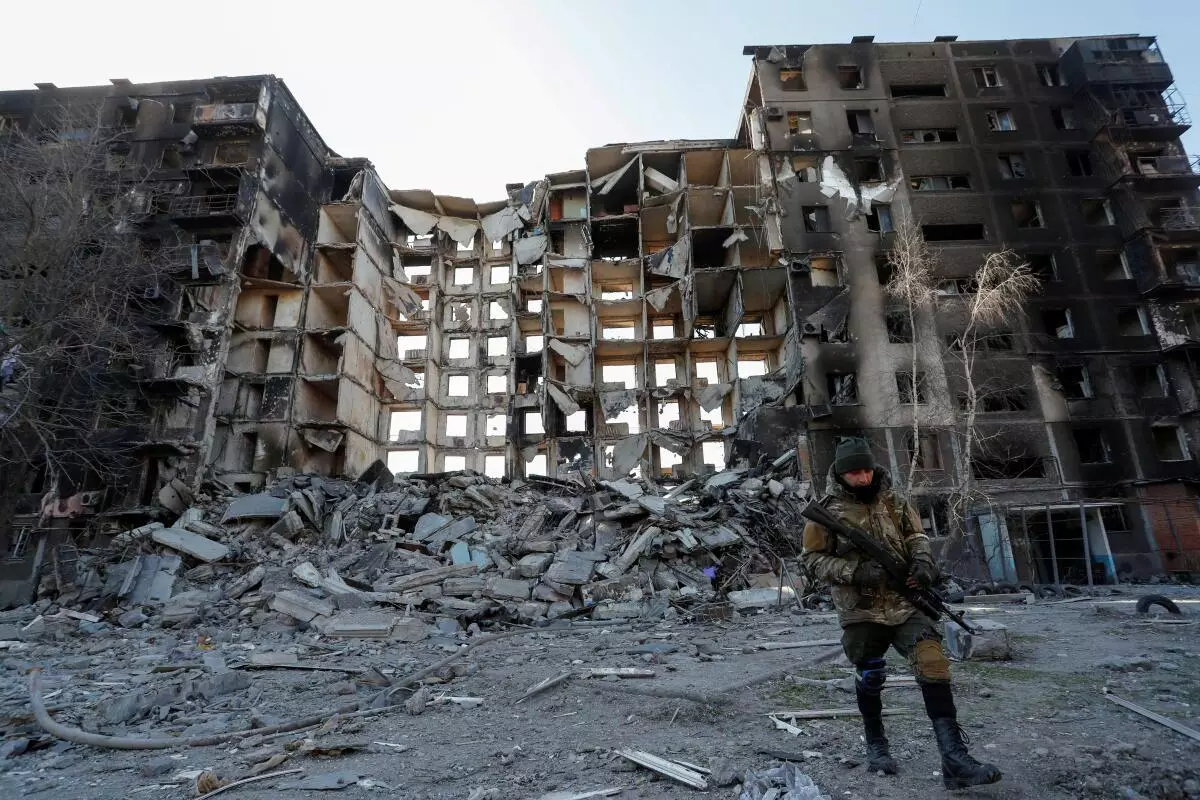 A service member of pro-Russian troops walks near an apartment building destroyed in the course of Ukraine-Russia conflict in the besieged southern port city of Mariupol, Ukraine March 28, 2022