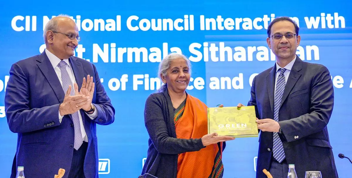 Finance Minister Nirmala Sitharaman receive a book from CII President Sanjiv Bajaj as CII President-designate R Dinesh applauds during an interaction with CII National Council members, in New Delhi, on Tuesday