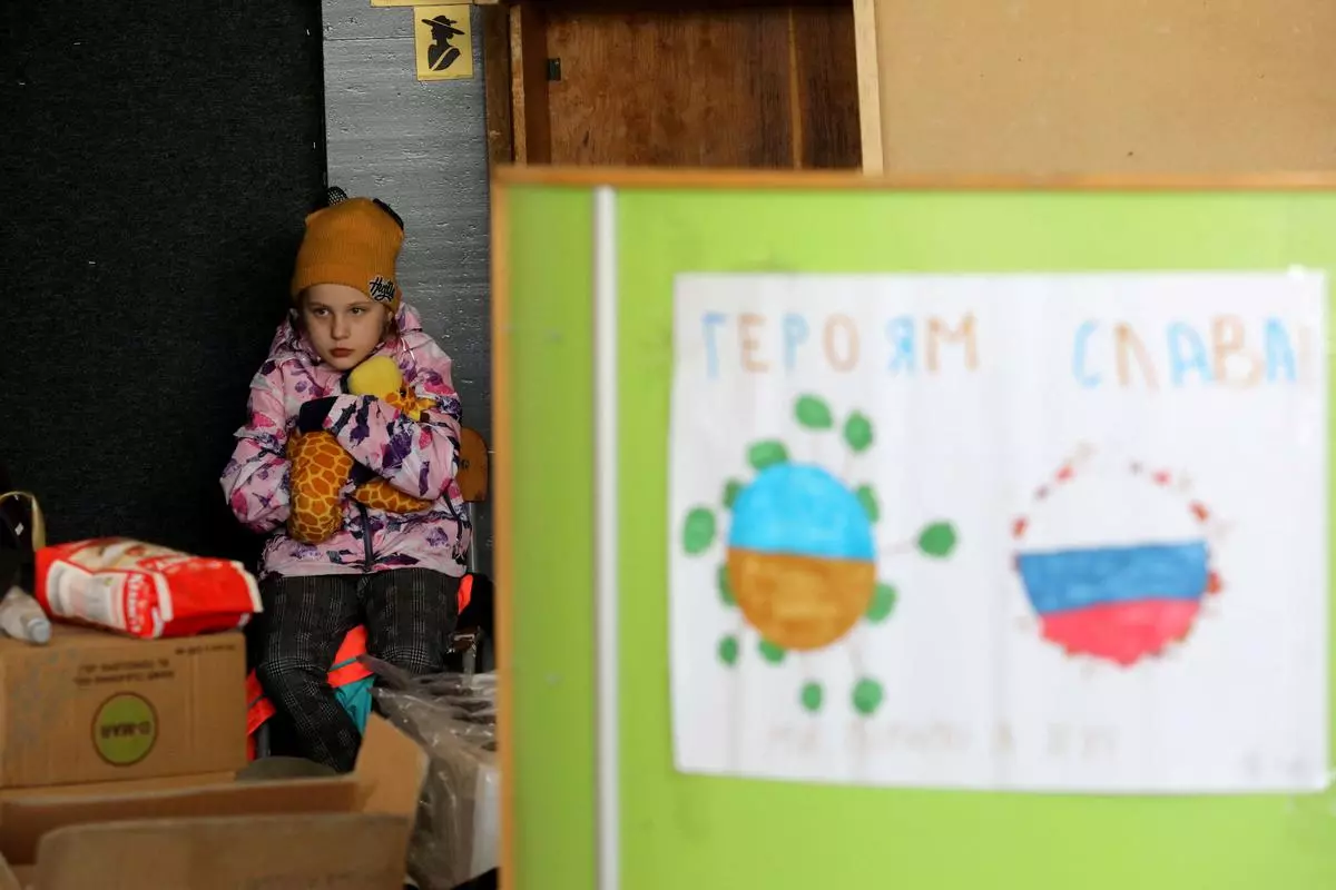 A girl looks on as she sits next to humanitarian aid amid Russia’s invasion of Ukraine, in Brovary, Kyiv region, Ukraine.  REUTERS/Mykola Tymchenko 