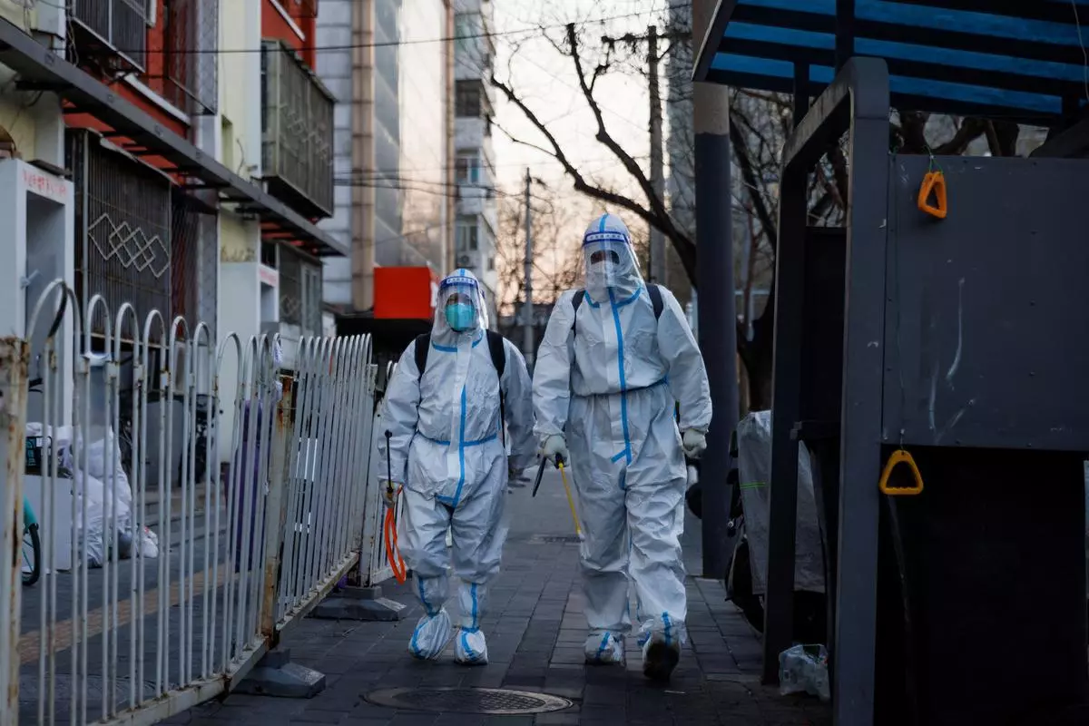 Pandemic prevention workers in protective suits walk in a street as coronavirus disease (COVID-19) outbreaks continue in Beijing