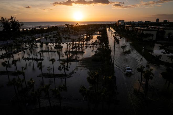 A drone view of a pick-up truck driving through a flooded street following Hurricane Milton in Siesta Key, Florida, U.S., October 10, 2024.  