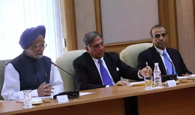 Prime Minister Manmohan Singh speaks during a meeting with corporate dignitaries at his residence in New Delhi on Saturday. Tata Group Chairman Ratan Tata and Bharti Enterprises Chairman Sunil Bharti Mittal are also seen in the picture.