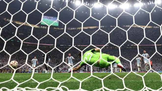 Kylian Mbappé of France scores the second goal against Emiliano Martinez of Argentina.