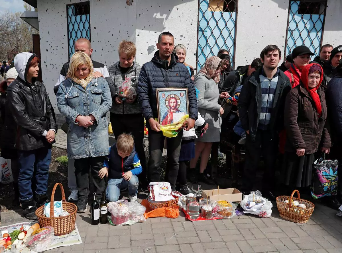 Believers attend a blessing of traditional Easter food baskets at the Svyato-Troitsky church, amid Ukraine-Russia conflict, in the southern port city of Mariupol, Ukraine April 24, 2022. 