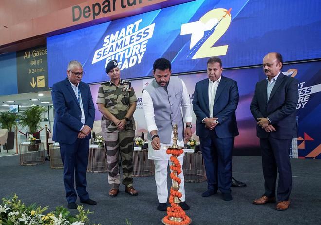 Union Minister of Civil Aviation Ram Mohan Naidu Kinjarapu lights the ceremonial lamp during the inauguration of the newly refurbished Terminal 2 of Delhi Airport, in New Delhi on Saturday