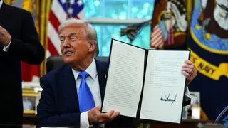US President Donald Trump holds a signed executive order authorizing the Trump Gold Card in the Oval Office of the White House in Washington, DC, US, on Friday, Sept. 19, 2025. Trump is signing a proclamation that would move to extensively overhaul the H-1B visa program, requiring a $100,000 fee for applications in a bid to curb overuse, according to a White House official familiar with the matter. Photographer: 