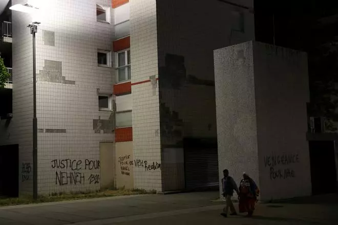 स्थानीय निवासी पड़ोस में इमारतों की दीवारों पर लिखे वाक्यांशों को देखते हुए चलते हैं, जहां रविवार को फ्रांस के नैनटेरे में यातायात रोकने के दौरान एक 17 वर्षीय किशोर नाहेल को एक फ्रांसीसी पुलिस अधिकारी ने मार डाला था।  दीवारों पर 