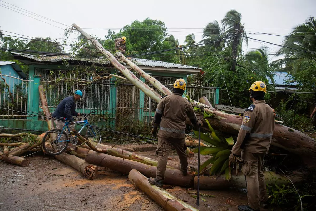 Employees work to clear a street of downed trees and light poles down in the aftermath of Hurricane Julia, in Bluefields, Nicaragua October 9, 2022. REUTERS/Maynor Valenzuela
