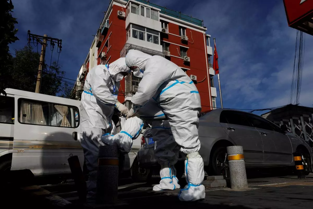 Pandemic prevention workers in protective suits prepare to enter an apartment compound that was placed under lockdown as the outbreaks of Covid-19 continue in Beijing, China
