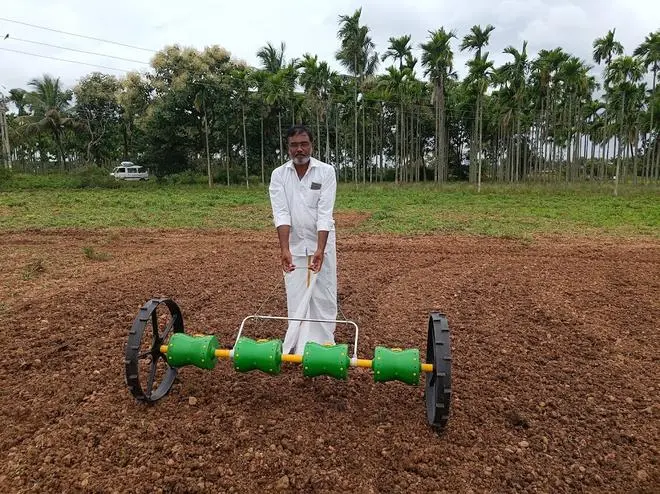 Farmer Vijay Kumar trying out the direct seeded paddy seeder at a demo plot in Bilisanur, Karnataka 