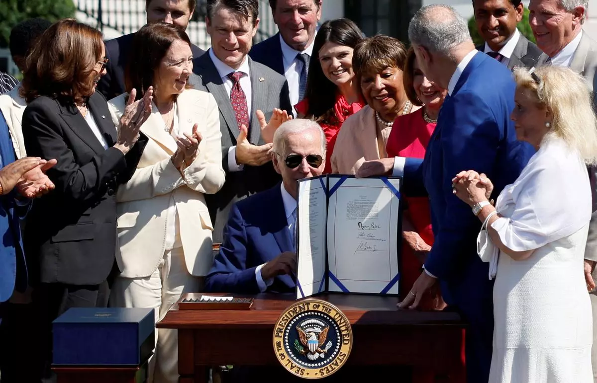 U.S. President Joe Biden signs the CHIPS and Science Act of 2022 alongside Vice President Kamala Harris and House of Representatives Speaker Nancy Pelosi. 