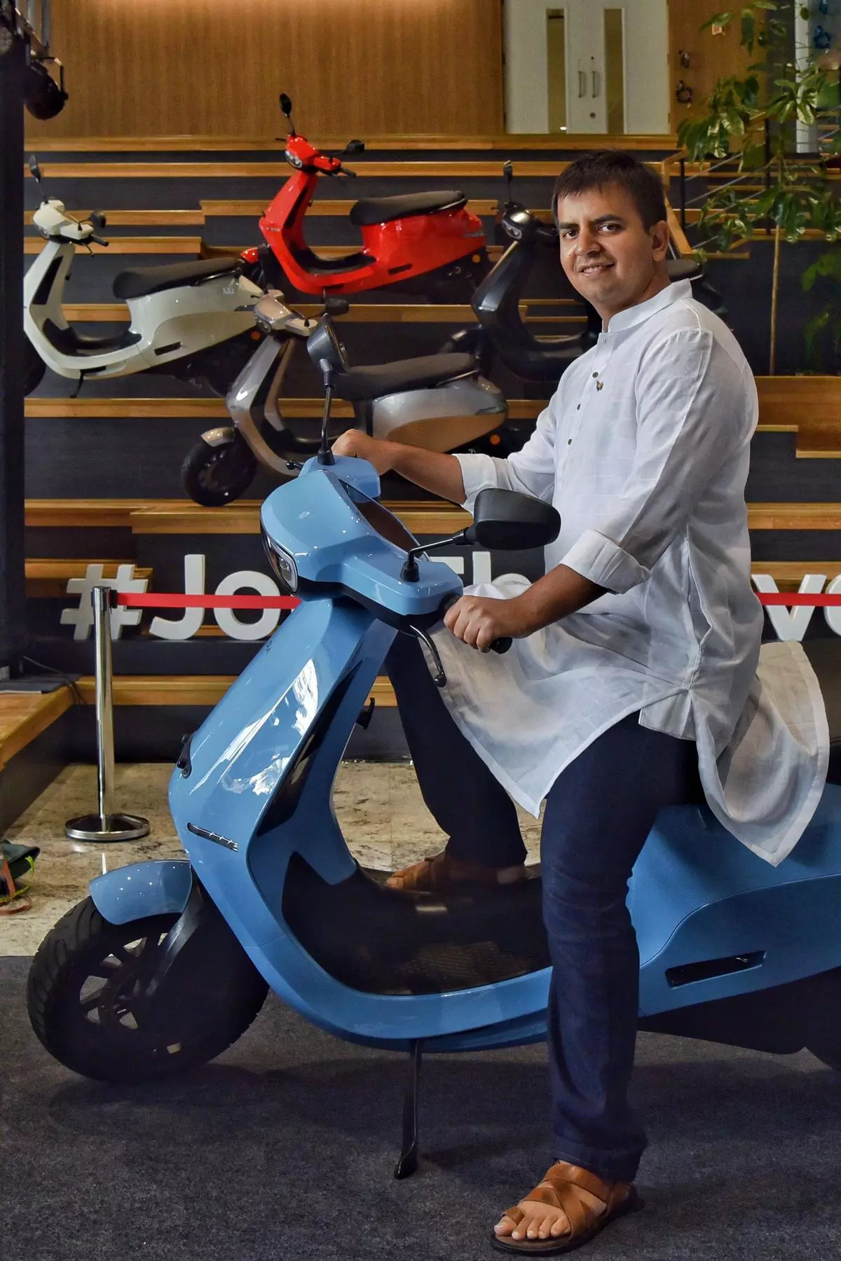Indian entrepreneur, co-founder and CEO of Ola, Bhavish Aggarwal, poses for a photograph with the new Ola electric scooter during its launch at the Ola headquarters in Bangalore on August 15 