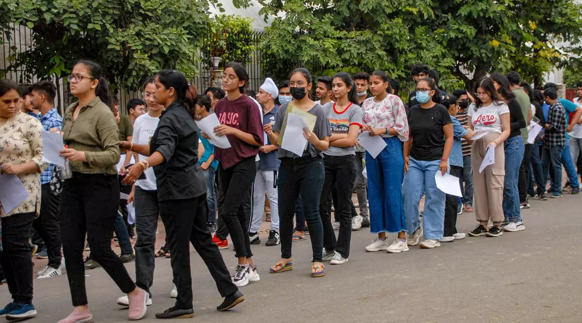 Students wait in a queue to appear for the Common University Entrance Test (CUET)
