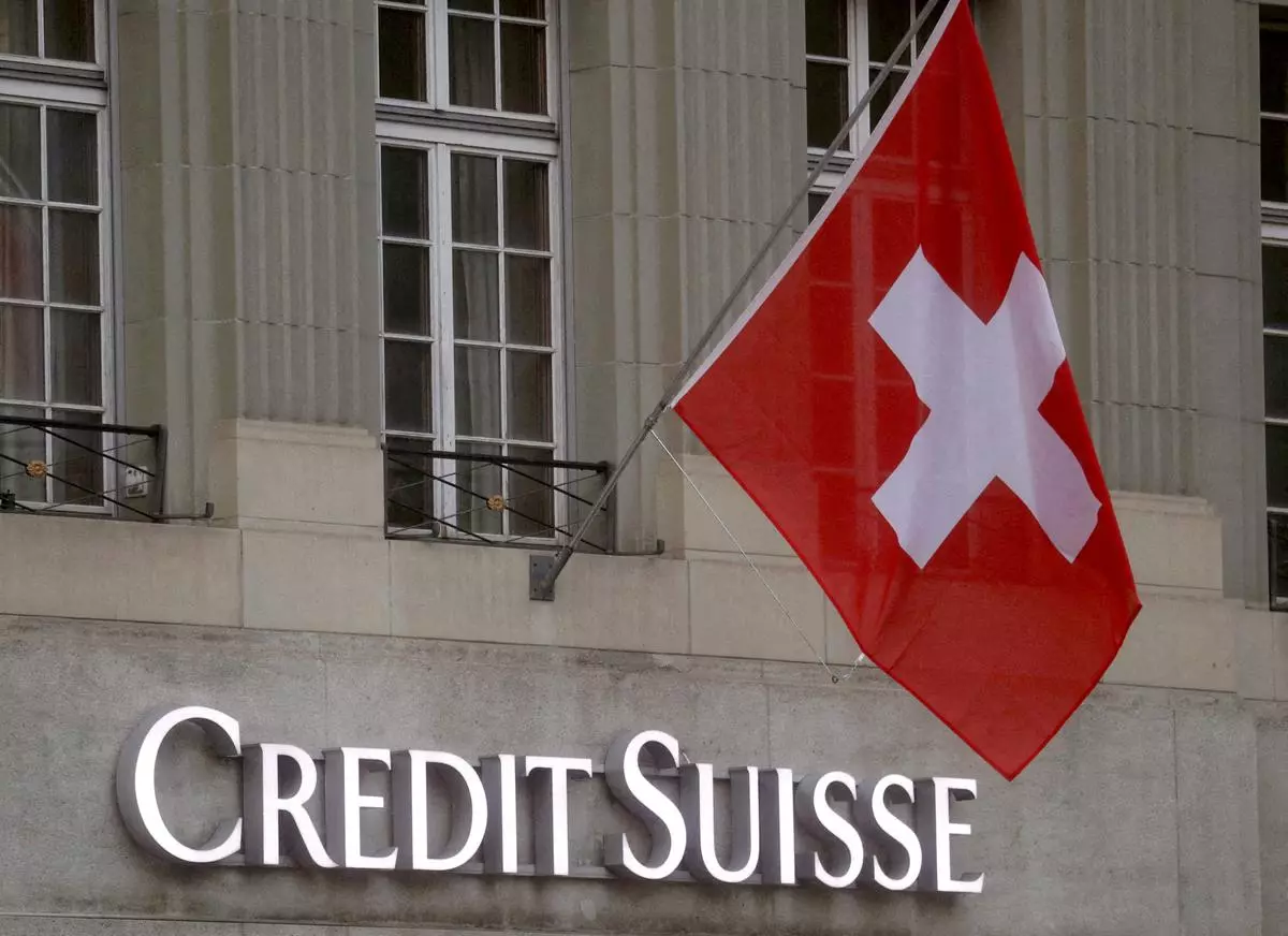 File Photo: Switzerland’s national flag flies above a logo of Credit Suisse.