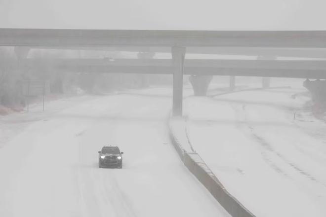 A vehicle travels westbound in blizzard conditions during a winter storm on Interstate 70 in Topeka, Kansas, U.S. January 5, 2025.