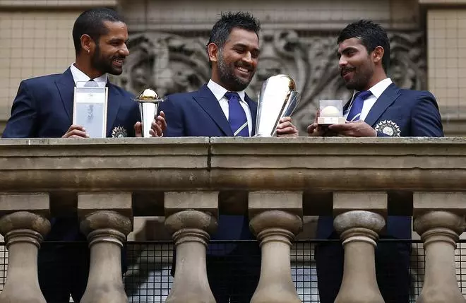 India’s cricket players Shikhar Dhawan (L), Mahendra Singh Dhoni (C) and Ravindra Jadeja pose with the ICC Champions Trophy on the balcony of the City Council building in Birmingham, central England, June 24, 2013.