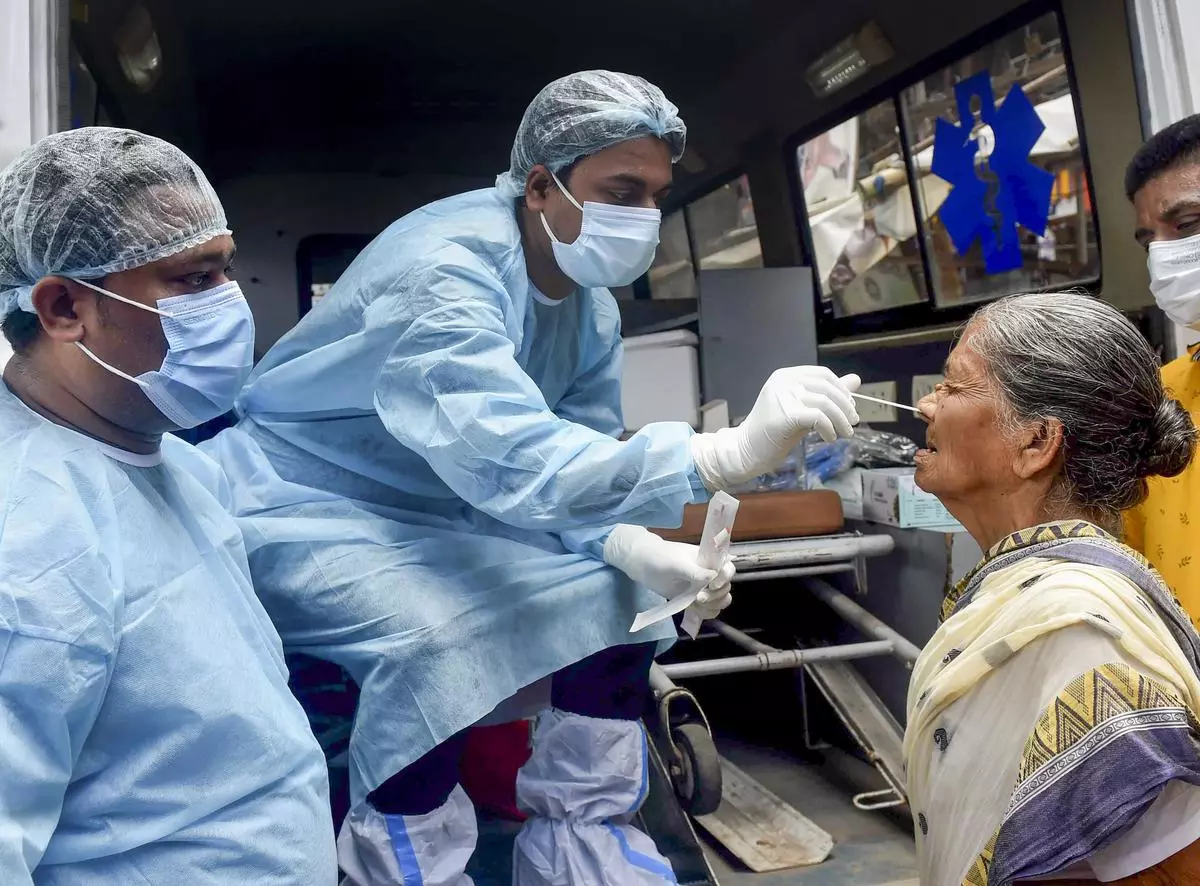 A healthcare worker takes a swab sample of a woman for Covid-19 testing amid a surge in coronavirus cases, in Kolkata.