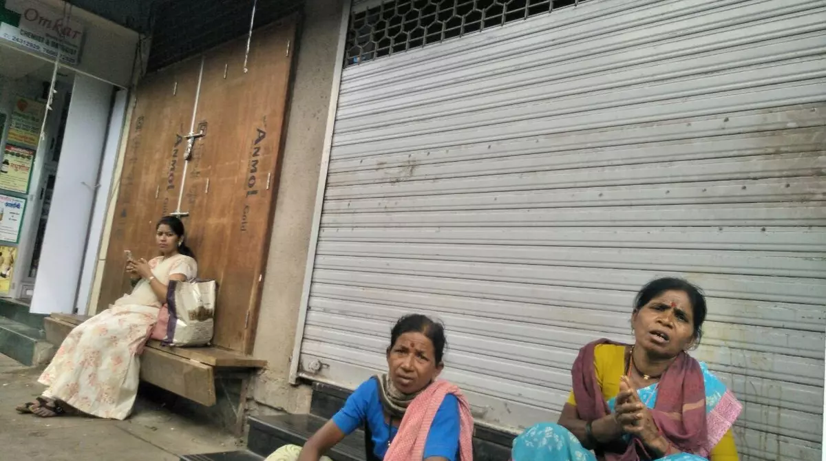 Women sit outside the downed shutters of a shop in Mumbai during the Bharat Bandh, called by the Opposition parties to protest the fuel price rise, on Monday.