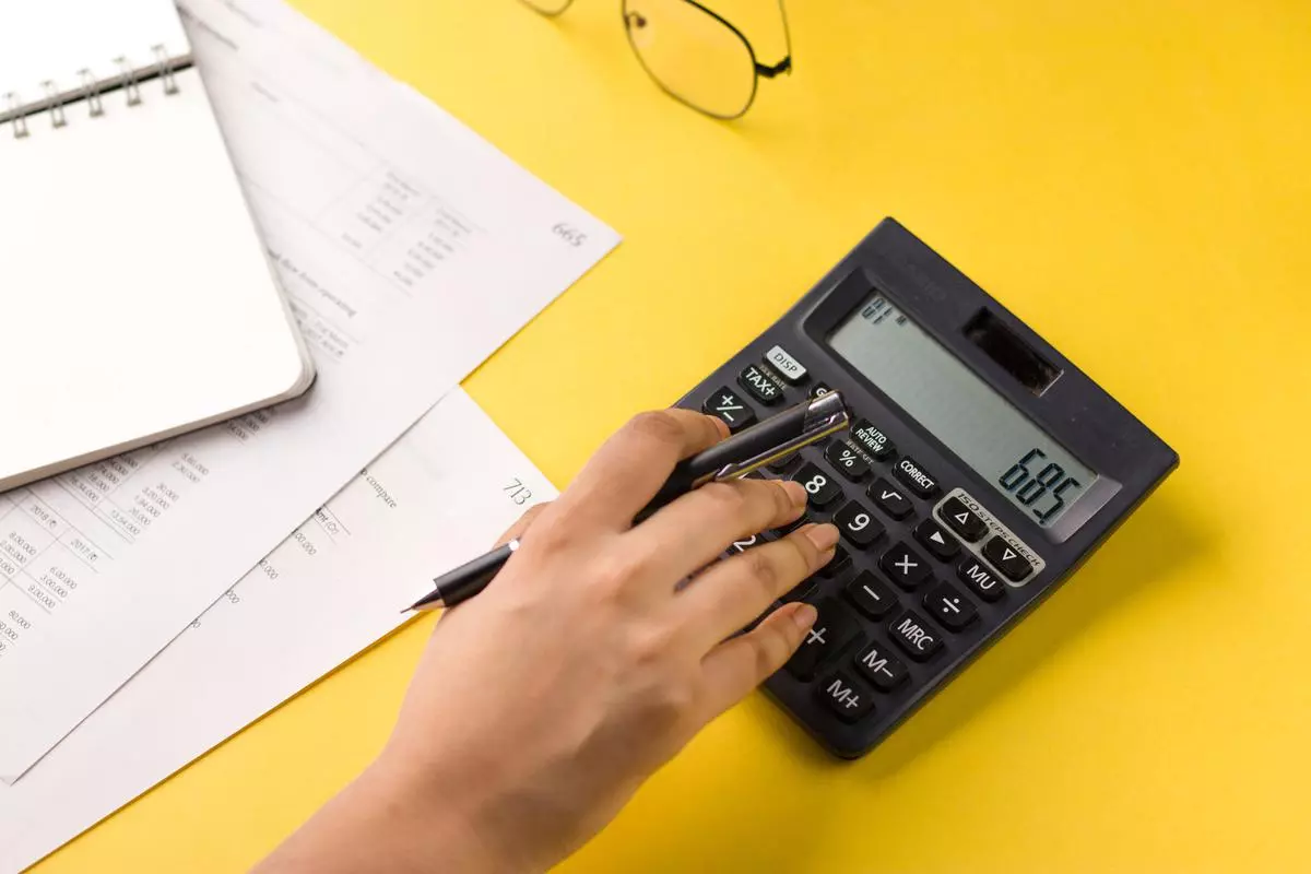 Closeup of using calculator on yellow background stock image. istock photo for BL