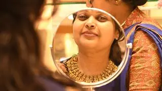 A woman buying gold ornaments at a jewellery showroom on the occasion of Dhanteras and the upcoming Diwali festival  A woman buying gold ornaments at a jewellery showroom on the occasion of Dhanteras and the upcoming Diwali festival