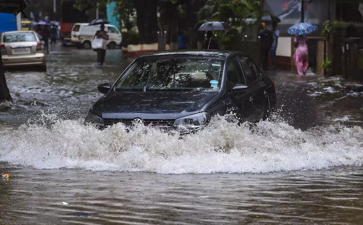 Vehicles ply on a flooded road following heavy monsoon rains in Mumbai, on Tuesday.