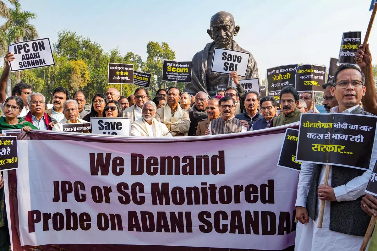 Opposition parties’ MPs stage a protest over Adani row at the Gandhi statue in the Parliament complex, in New Delhi, Monday