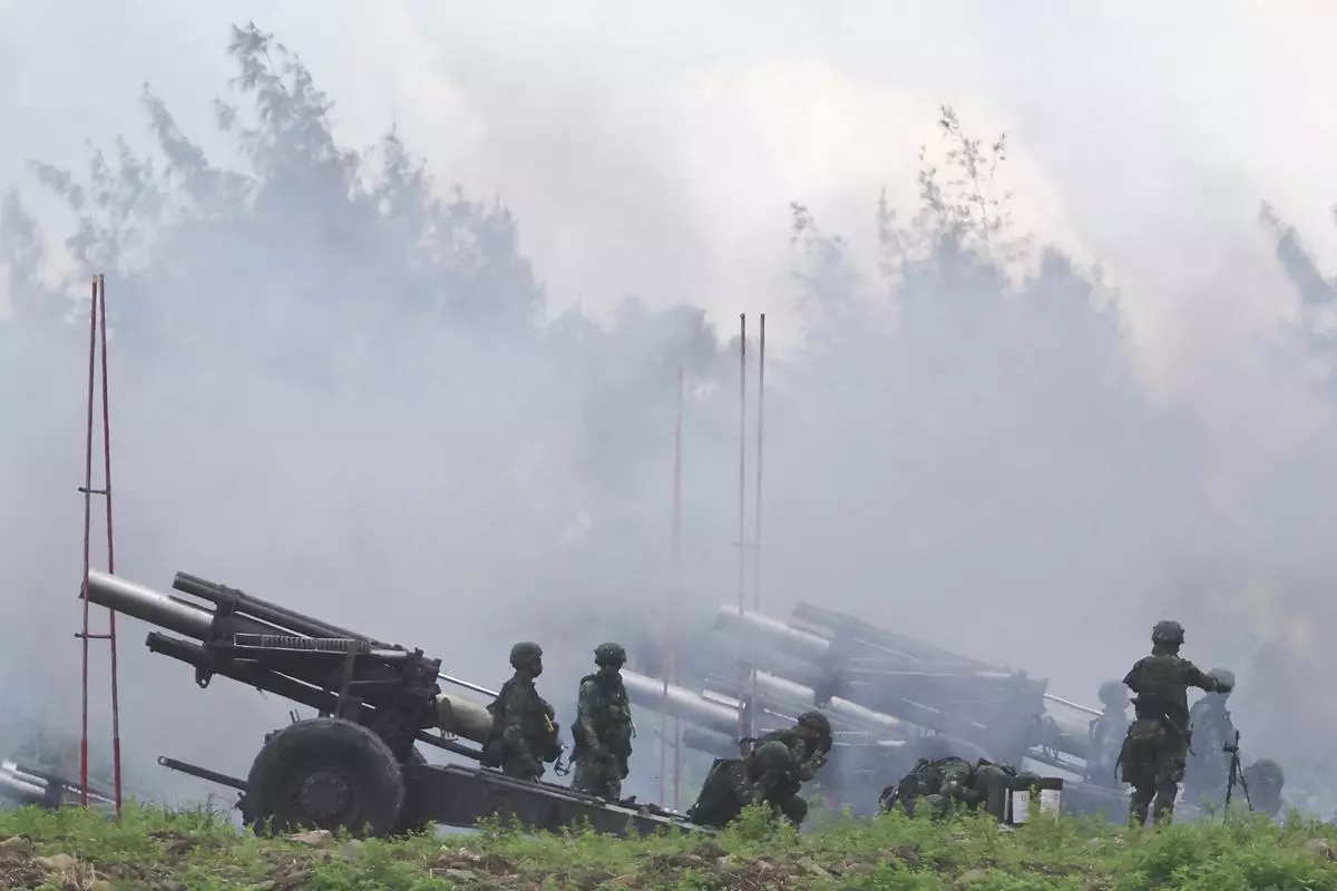 Taiwanese soldiers fire 155mm howitzers during an annual live fire military exercise in Pingtung county, southern Taiwan on Tuesday. 