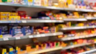 Defocused food store shelf with pre-packaged food, blurred