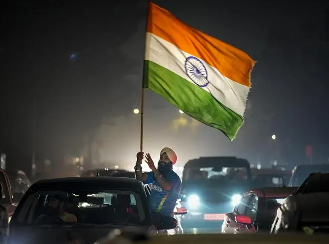New Delhi: A man waves the Indian tricolour in celebration after the Indian cricket team won the ICC Women's World Cup 2025, near the India Gate, in New Delhi, Sunday, Nov. 2, 2025.  New Delhi: A man waves the Indian tricolour in celebration after the Indian cricket team won the ICC Women's World Cup 2025, near the India Gate, in New Delhi, Sunday, Nov. 2, 2025.