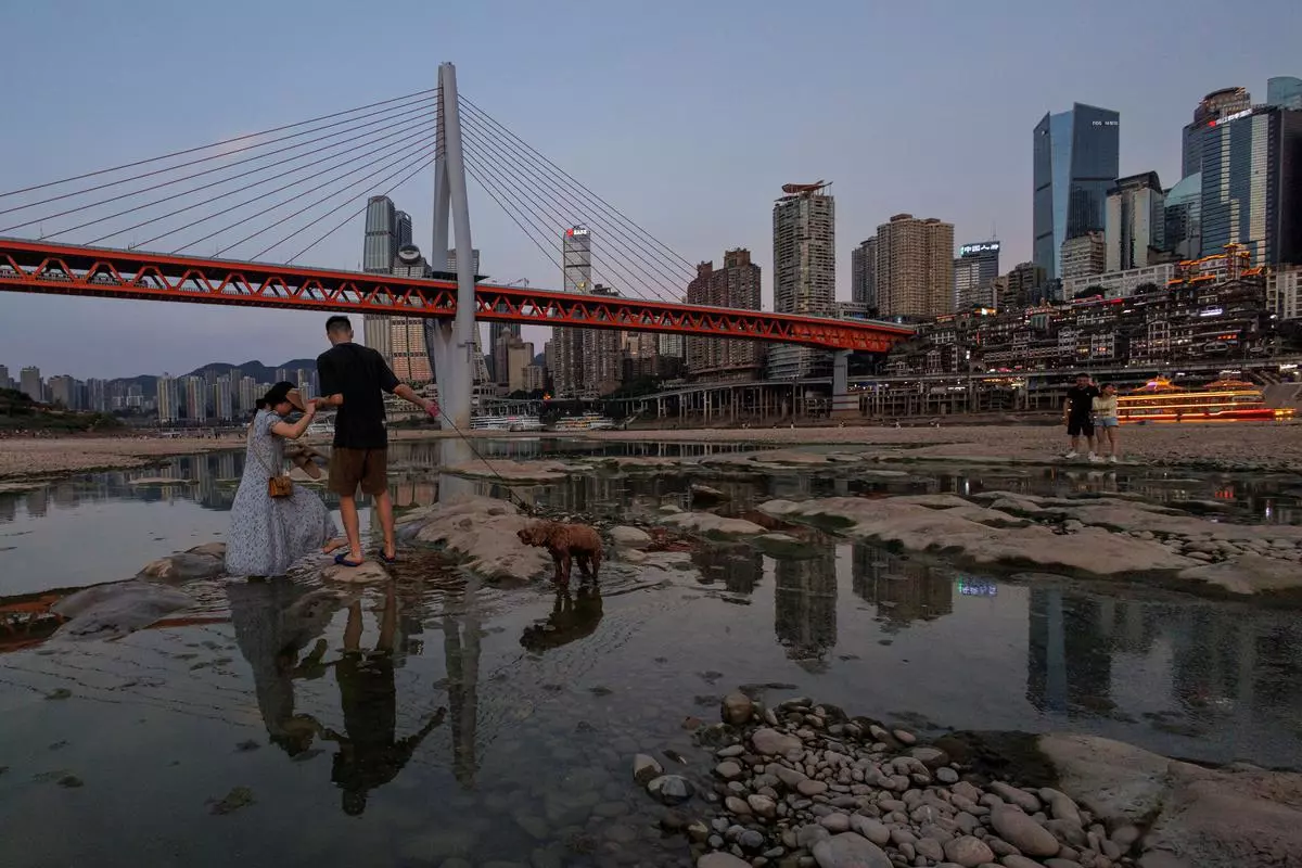 People walk on the partially dried-up riverbed of the Jialing river, a tributary of the Yangtze, that is approaching record-low water levels during a regional drought in Chongqing, China