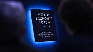 An illuminated World Economic Forum sign on the wall inside a panel session on the opening day of the World Economic Forum (WEF) in Davos, Switzerland An illuminated World Economic Forum sign on the wall inside a panel session on the opening day of the World Economic Forum (WEF) in Davos, Switzerland