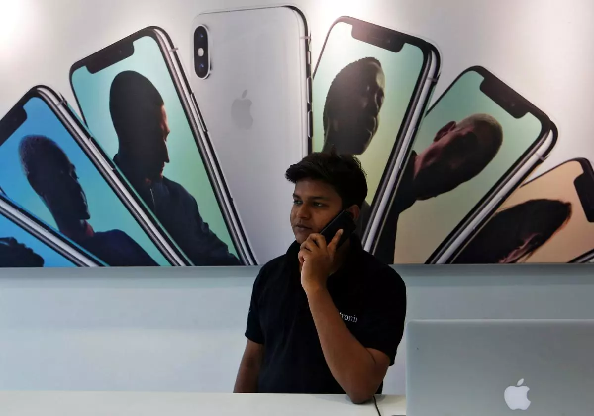 A salesperson speaks on the phone at an Apple reseller store.  REUTERS/Francis Mascarenhas/File Photo