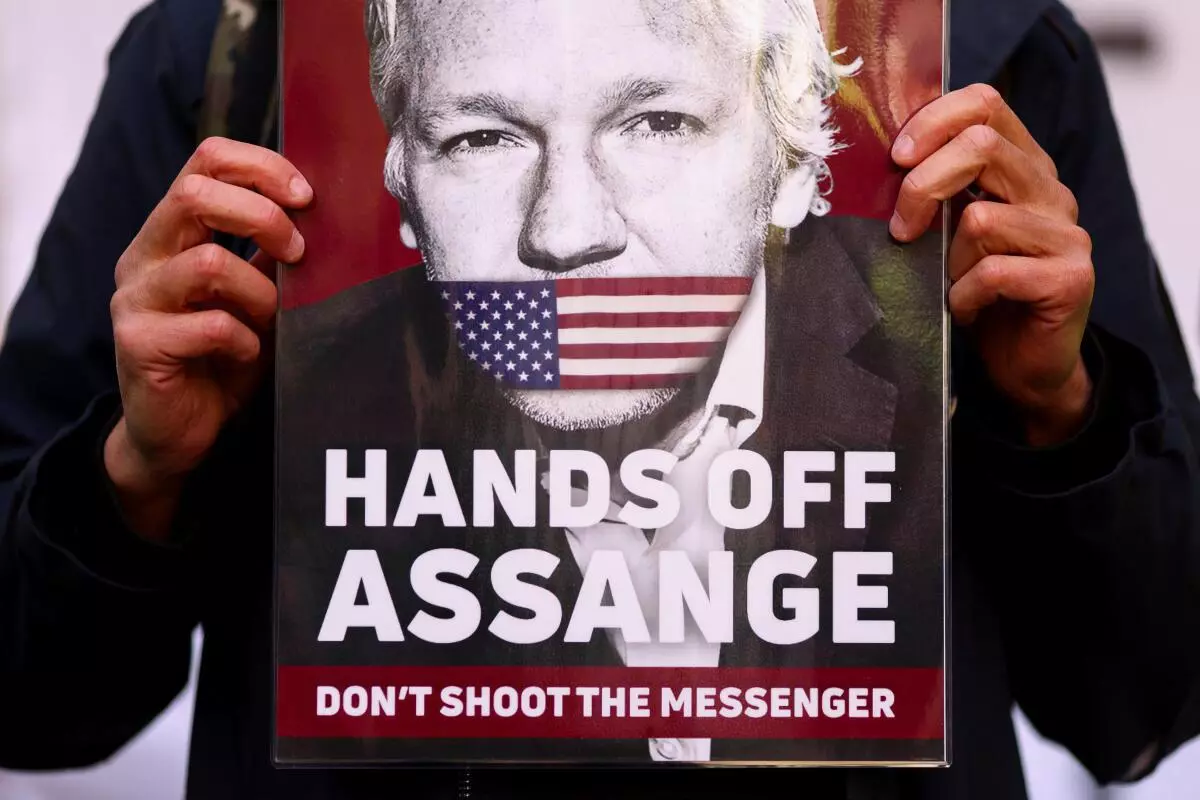 A supporter of Julian Assange displays a placard, outside the Westminster Magistrates’ Court in London, Britain April 20, 2022. REUTERS