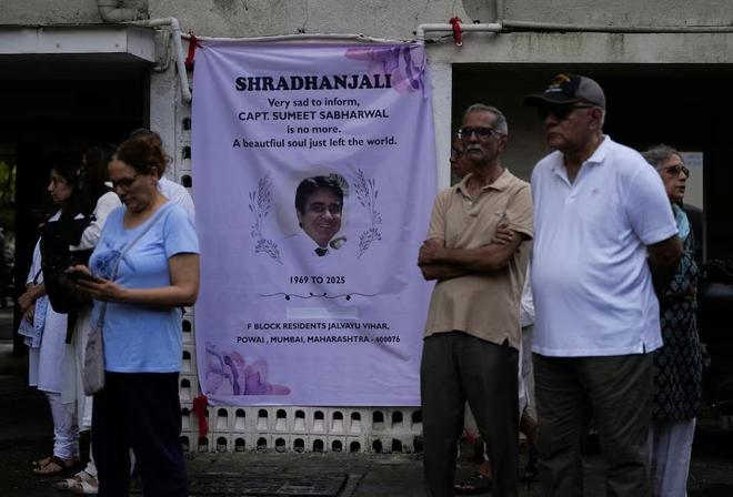 People stand next to a condolence banner as they wait for the body of Sumeet Sabharwal, a pilot who died when an Air India Boeing 787-8 Dreamliner crashed during take-off from an airport, to be handed over to his family in Mumbai, India, June 17, 2025. People stand next to a condolence banner as they wait for the body of Sumeet Sabharwal, a pilot who died when an Air India Boeing 787-8 Dreamliner crashed during take-off from an airport, to be handed over to his family in Mumbai, India, June 17, 2025.