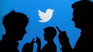 FILE PHOTO: People holding mobile phones are silhouetted against a backdrop projected with the Twitter logo in this illustration picture taken in  Warsaw September 27, 2013. REUTERS/Kacper Pempel/File Photo