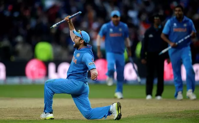 India’s Virat Kohli celebrates with a stump after his team won the ICC Champions Trophy final cricket match against England at Edgbaston cricket ground in Birmingham June 23, 2013.