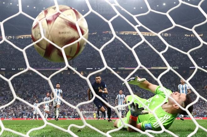 France's Kylian Mbappé scores his first goal from the penalty spot past Argentina's Emiliano Martinez.