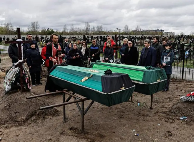 Relatives attend the funeral service of Anatolii Strilec, 68, who according to his family was killed by Russian soldiers while he was preparing food outside his building, and Fedorovskyi Dnytro, 51, before their burial, amid Russia’s invasion of Ukraine, at the cemetery in Bucha, Kyiv region, Ukraine April 26, 2022. Relatives attend the funeral service of Anatolii Strilec, 68, who according to his family was killed by Russian soldiers while he was preparing food outside his building, and Fedorovskyi Dnytro, 51, before their burial, amid Russia’s invasion of Ukraine, at the cemetery in Bucha, Kyiv region, Ukraine April 26, 2022.