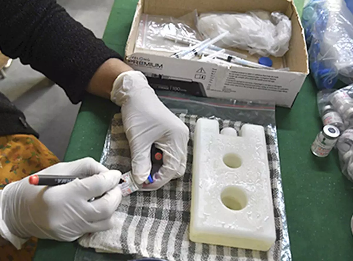  A medic writing date and time on a Covid-19 Covaxin vial before opening during the vaccination drive against corona virus at an Vaccination Centre.