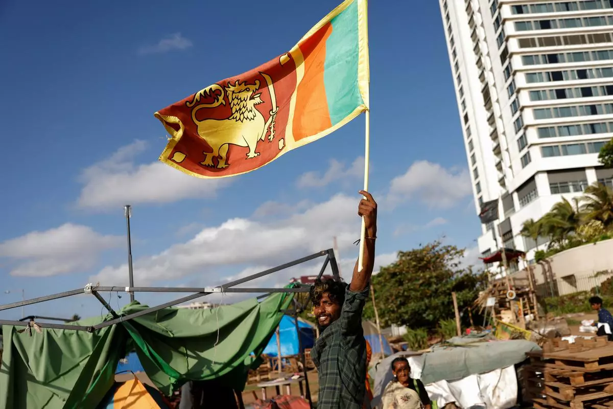 A protester holds a national flag at a tent camp that became the focal point of months-long nationwide demonstrations, in Colombo, Sri Lanka. The students were arrested at a recent protest in Colombo highlighting concerns including state repression and increasing cost of living.