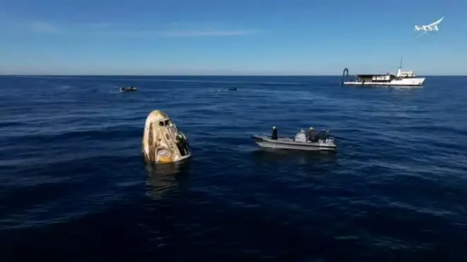 This still image from a NASA+ livestream shows recovery vessels approaching the Dragon capsule with the SpaceX Crew-9 astronauts shortly after splashdown on March 18, 2025, off the coast of Florida. The SpaceX craft is returning stranded astronauts Butch Wilmore and Suni Williams. They are joined onboard by NASA’s Nick Hague and Russian cosmonaut Aleksandr Gorbunov.  