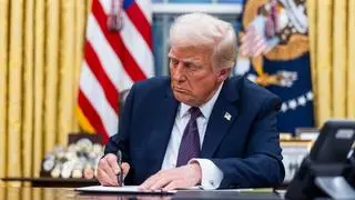 US President Donald Trump signs executive orders in the Oval Office of the White House in Washington, DC, US